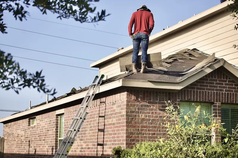 Professional roofer working on a residential roof in Leitchfield